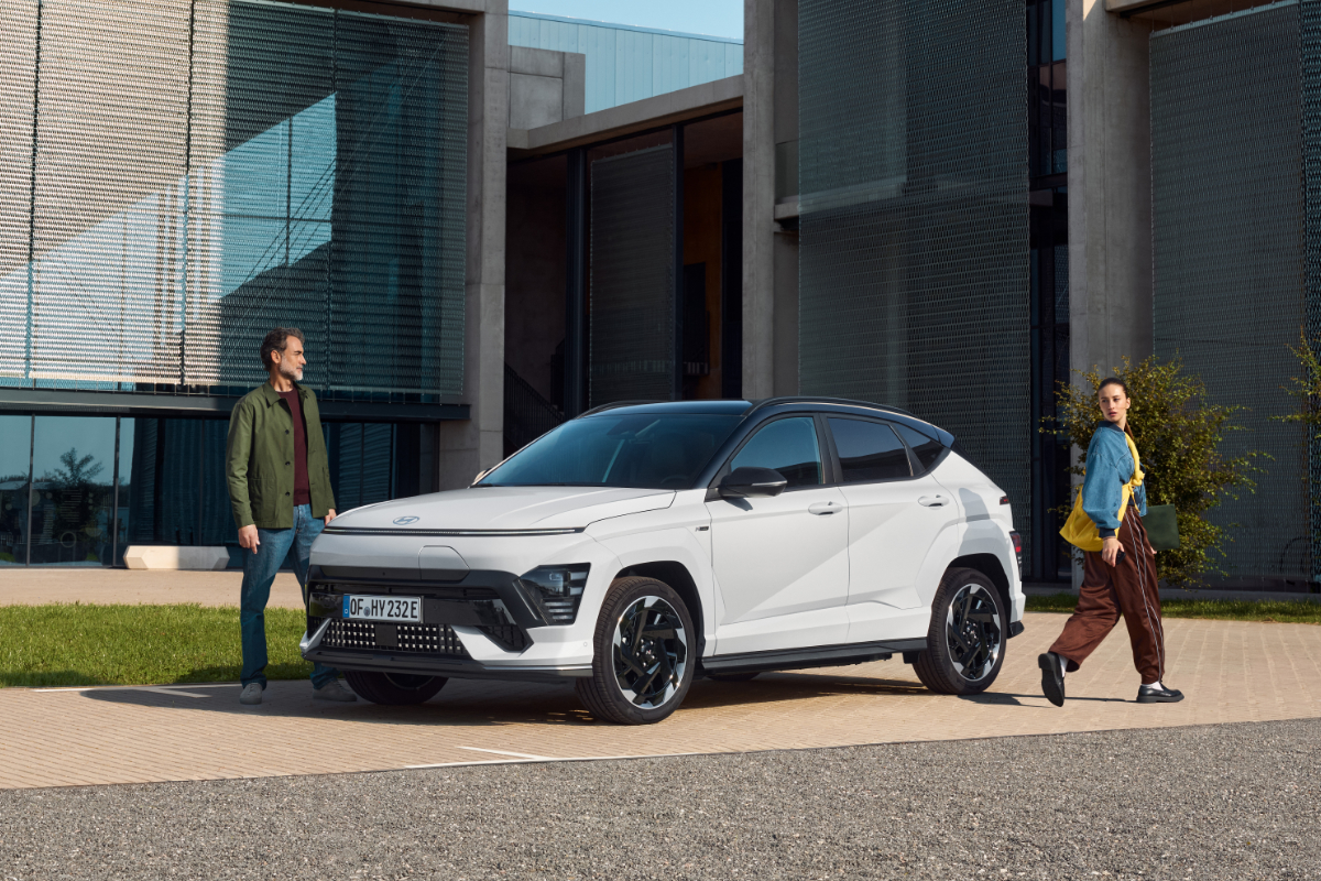Ein weisse Hyundai KONA steht vor Gebäude
