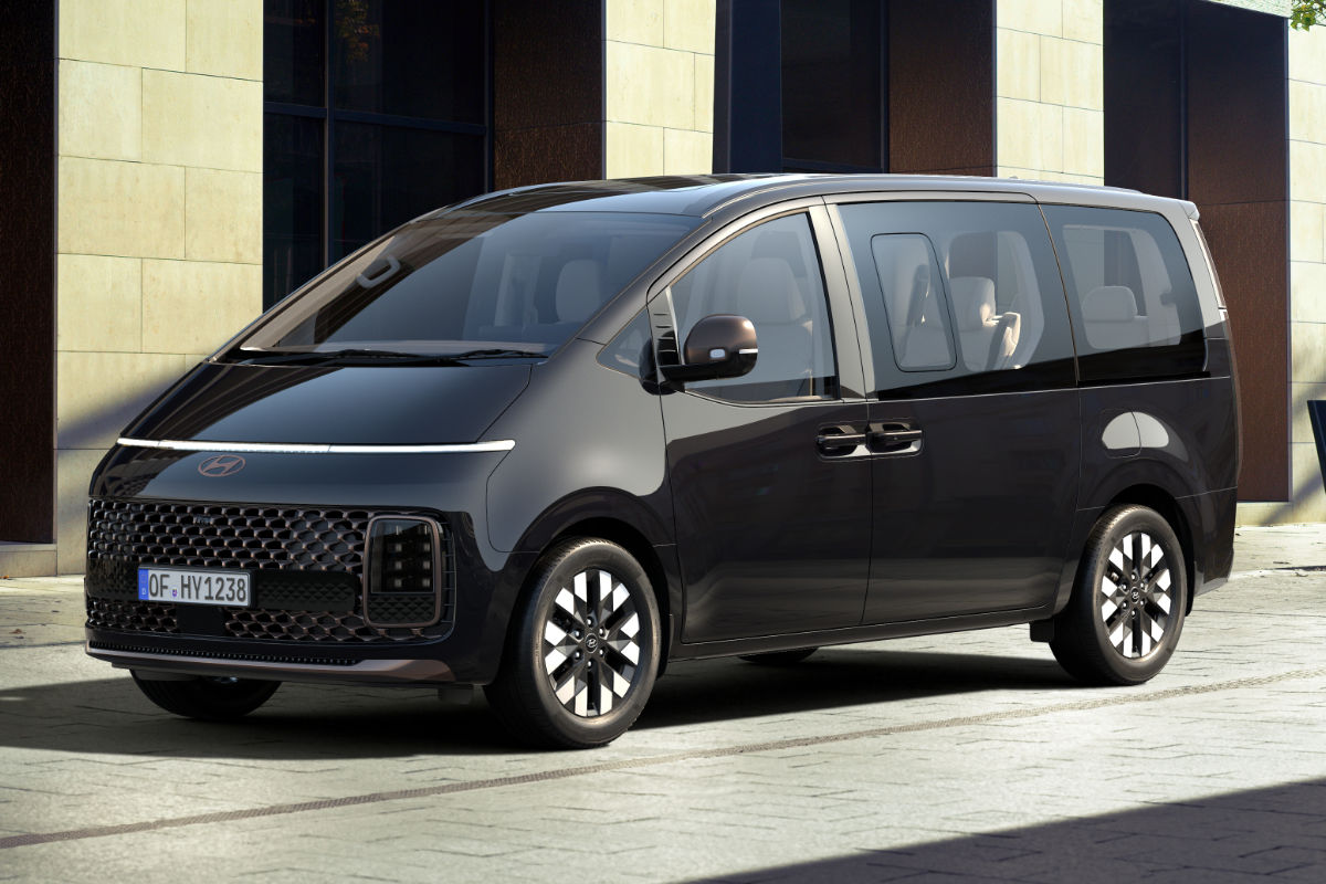 Ein schwartze Hyundai Staria steht vor Gebäude