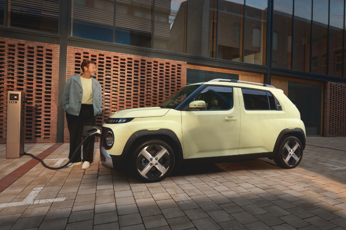 glückliche Frau steht vor einem grauen i10