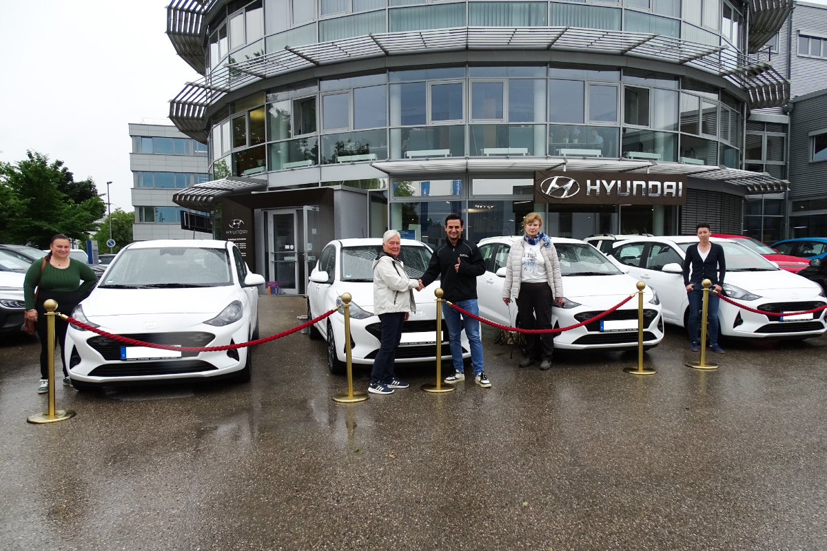 Auf dem Foto zu sehen ist unser Verkaufsberater Dario Zambuto bei der Übergabe der neuen Hyundai i10 an Frau Maisberger und ihr Team vom SAMA Pflegedienst.