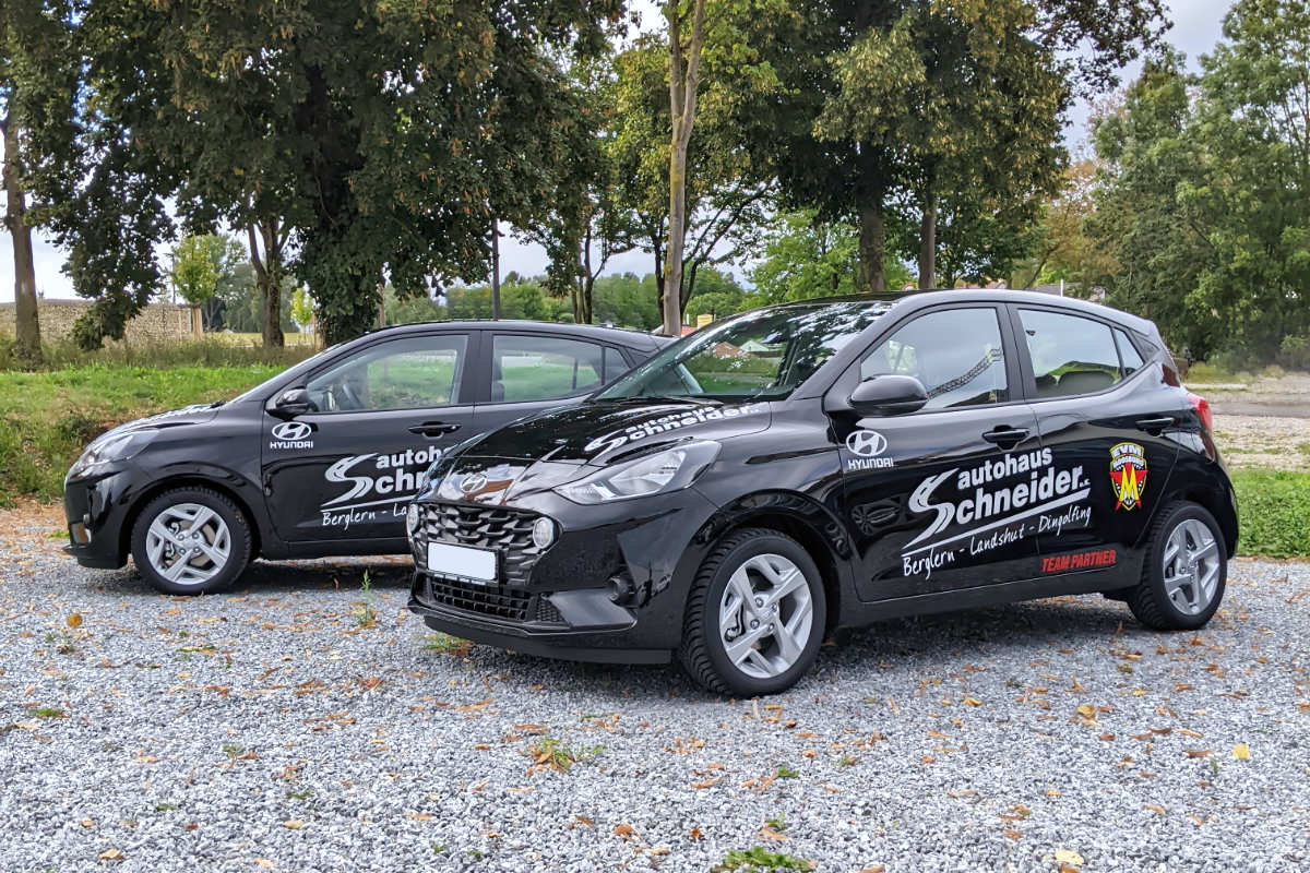 Zwei schwarzen Hyundai i10 stehen vor den Bäumen